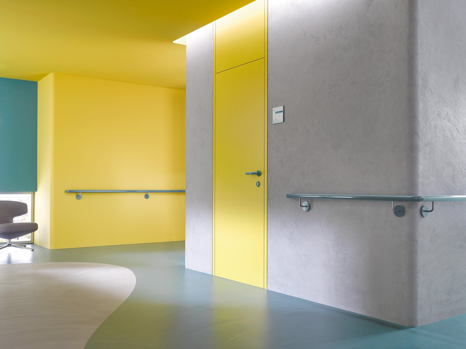 Corridor in a care building equipped with handrails in the colour aqua blue